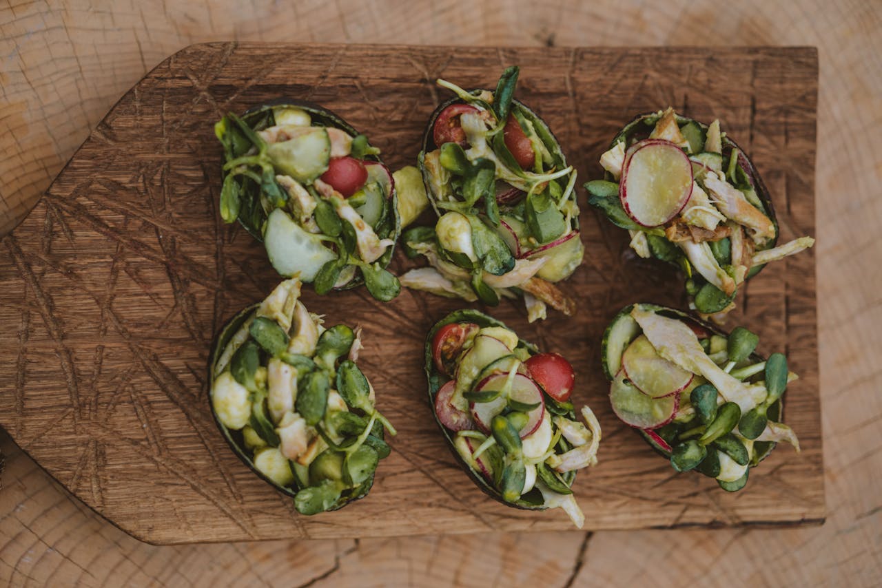 Healthy salad cups with fresh vegetables arranged on a rustic wooden board.