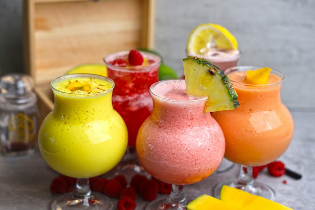 A vibrant selection of fruit mocktails with fresh garnishes, perfect for summer refreshments.